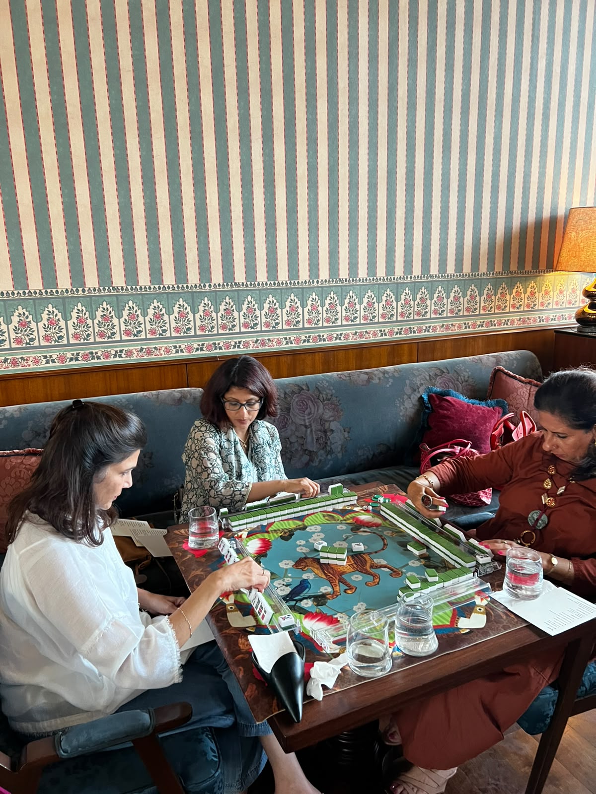 People playing Mahjong at a patterned table